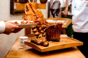 cook cuts fried ribs on cutting desk